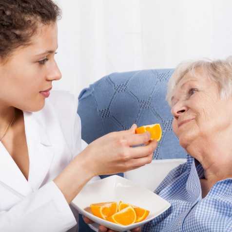nurse feeding elderly patient