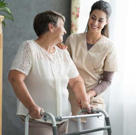 nurse helping elderly woman walk