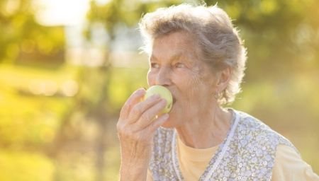 senior woman eating an apple
